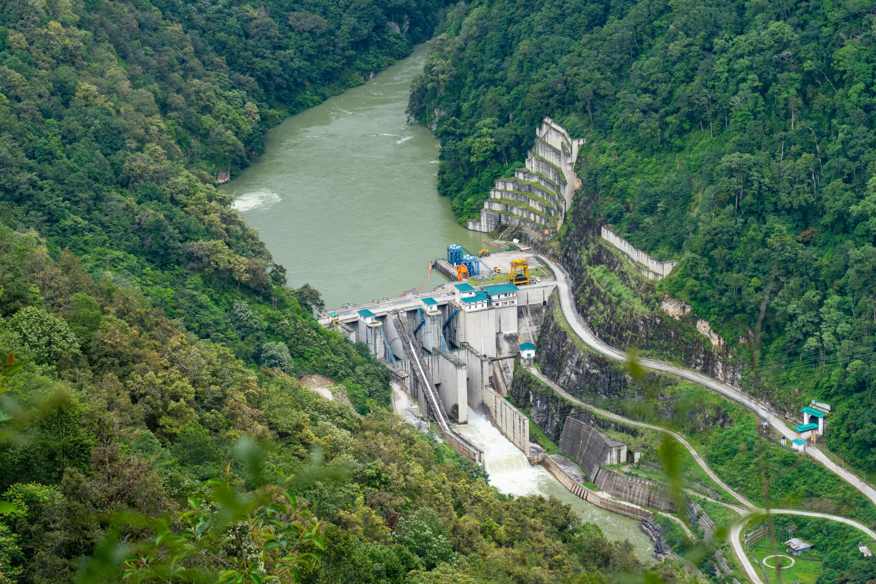 Hydropower dam in Bhutan surrounded by lush green mountains, highlighting environmental conservation in Bhutan, renewable energy, and sustainable development.
