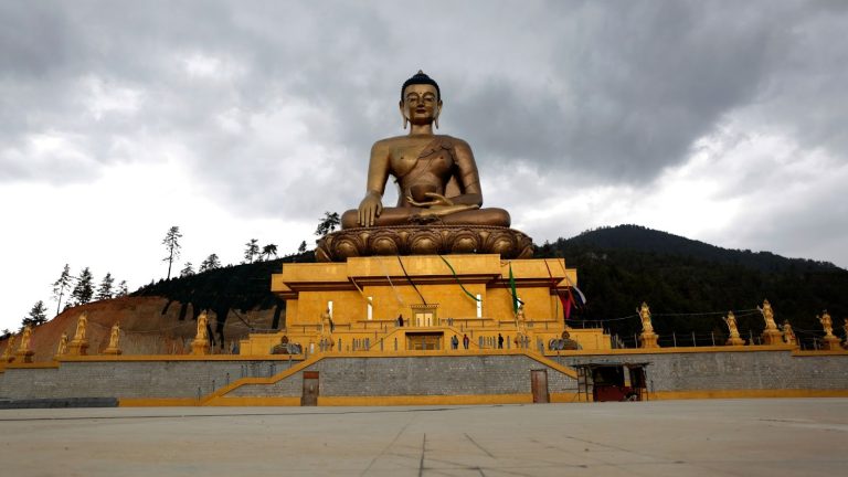 Buddha Dordenma statue with a traditional Bhutanese temple in Thimphu, highlighting environmental conservation in Bhutan, cultural preservation, and sustainable tourism.