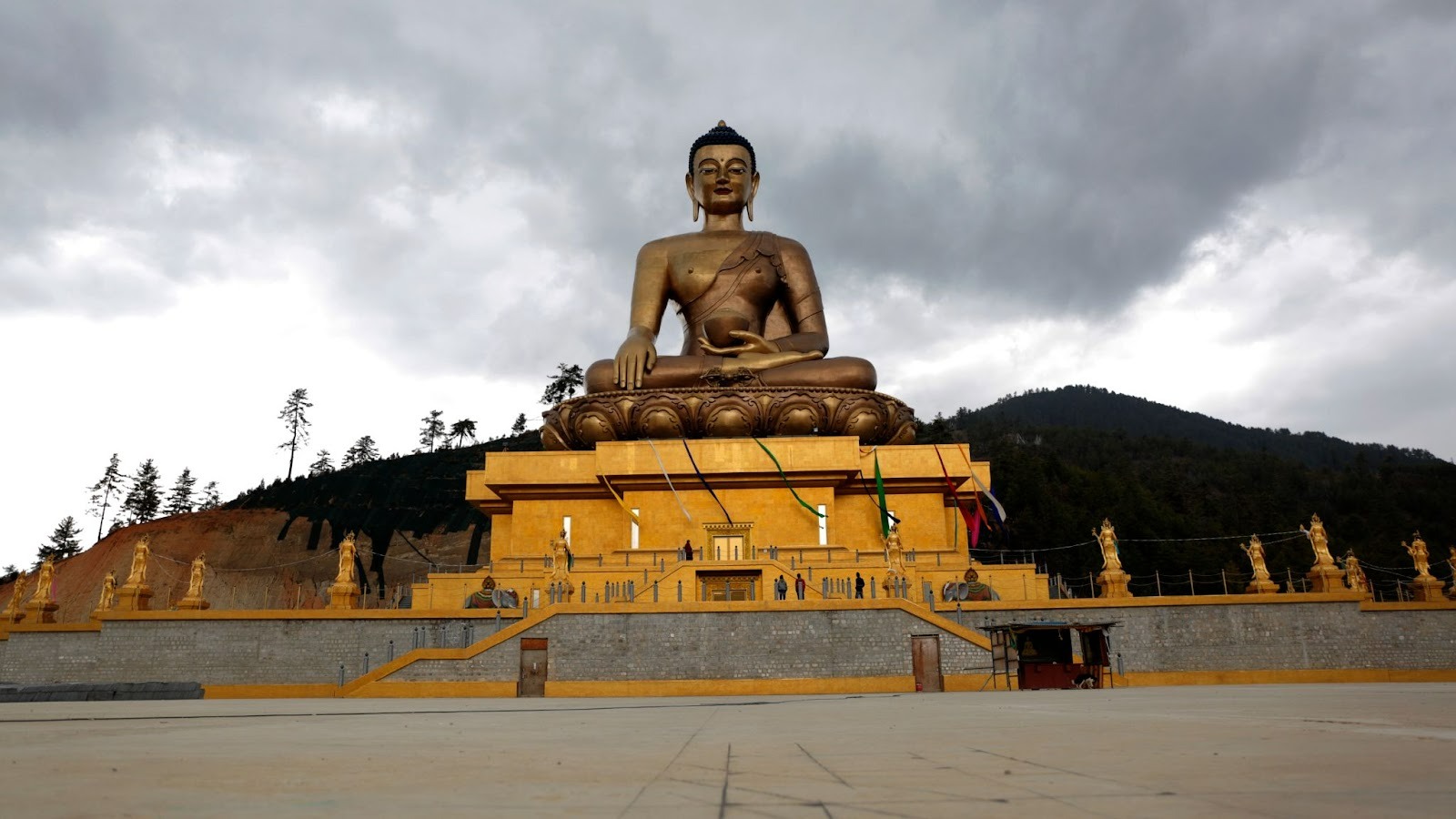 Buddha Dordenma statue with a traditional Bhutanese temple in Thimphu, highlighting environmental conservation in Bhutan, cultural preservation, and sustainable tourism.
